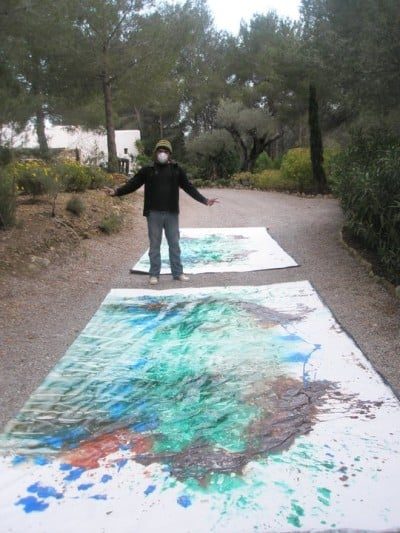 Marcos Shannon con dos lienzos de gran formato recién pintados en el camino de su casa en Ibiza